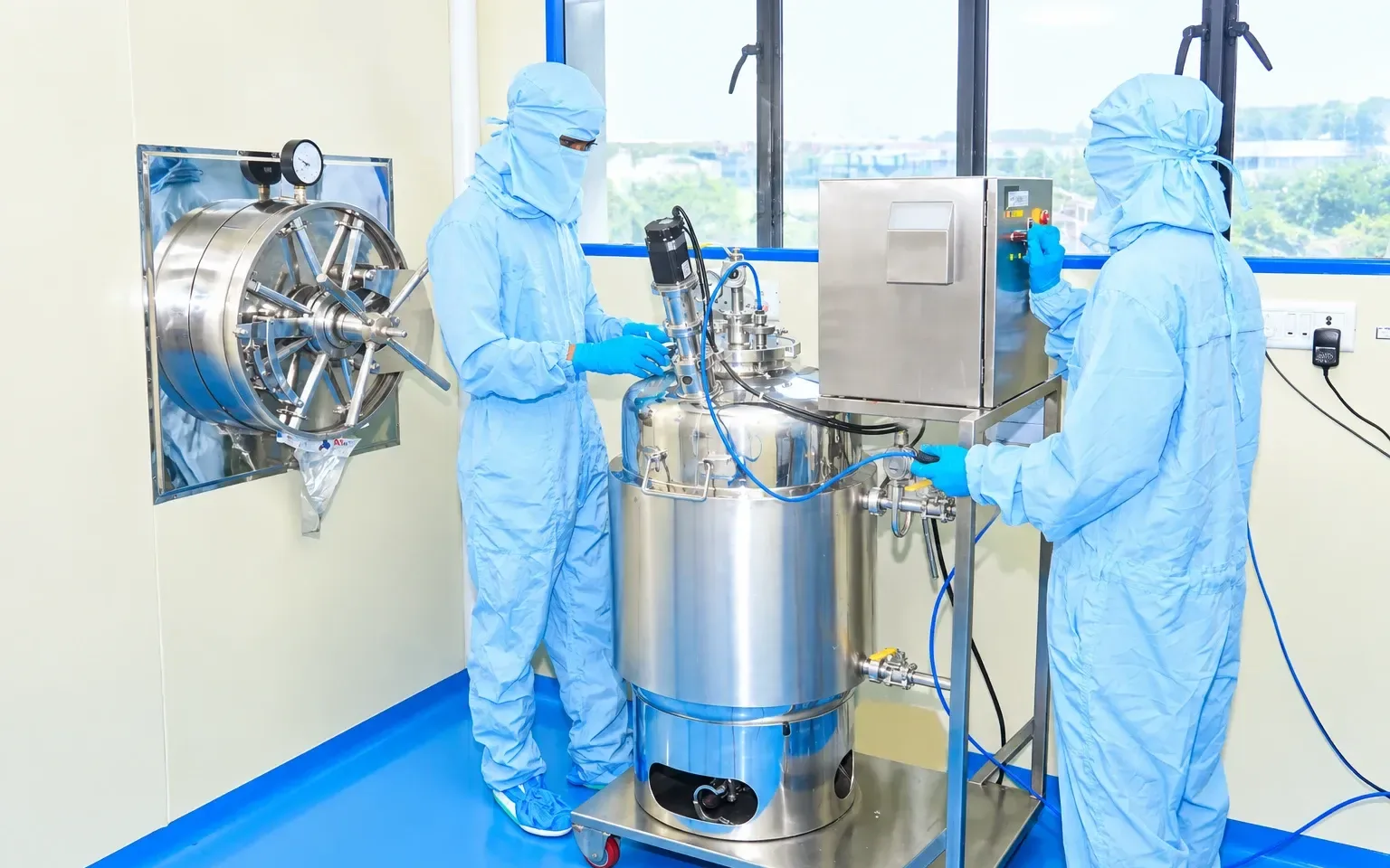 Two operators preparing an inoculation vessel together next to the autoclave