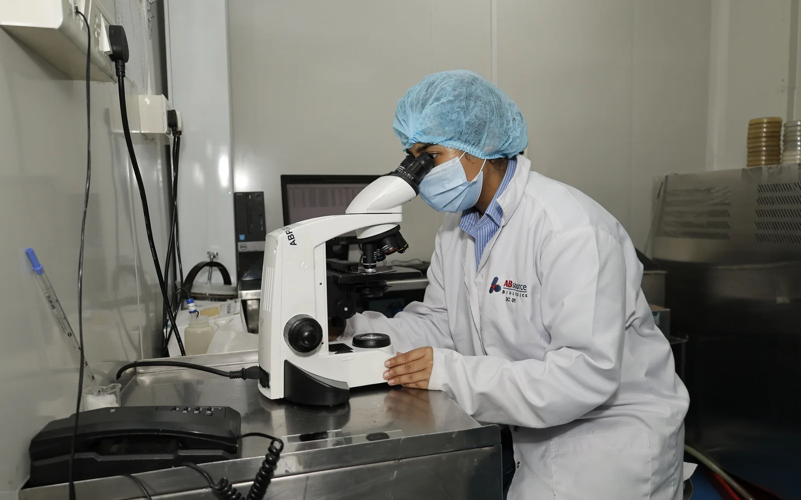A technologist examining a culture sample under the microscope